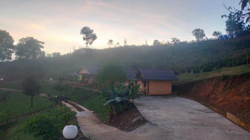 a small house in a field with a mountain at Mong Homestay Resort in Pang Ung