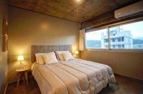 a bedroom with a large bed with a large window at Naranjo 9A in San Salvador de Jujuy