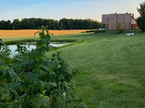 a field with a barn and a pond in the foreground at Glemuria in Kętrzyn