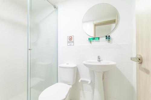a bathroom with a toilet and a sink and a mirror at Hotel Boutique Gao in Cúcuta