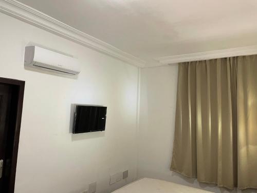 a white room with a tv on the wall at HOTEL LES ARCADES in Abomey-Calavi