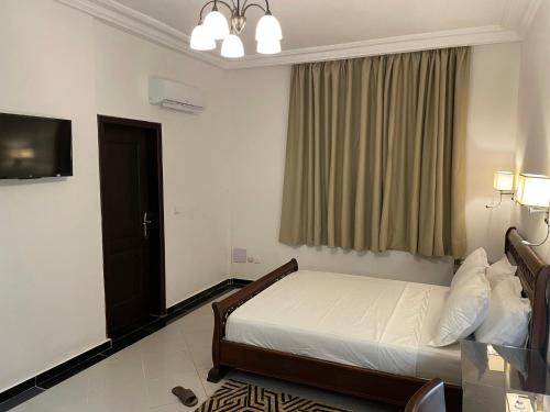 a bedroom with a bed and a television in it at HOTEL LES ARCADES in Abomey-Calavi