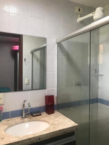 a bathroom with a sink and a glass shower at Flat WinterVille Residence - Gravatá in Gravatá