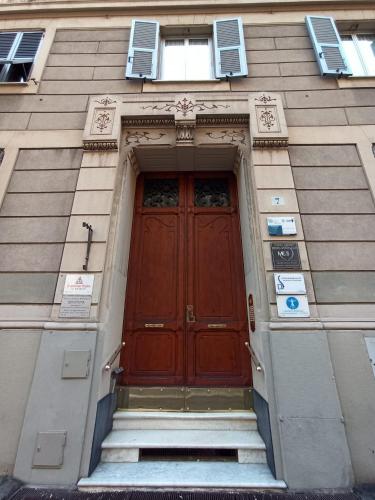 a large wooden door on a building with stairs at Paradise Rooms - Brignole Station in Genova