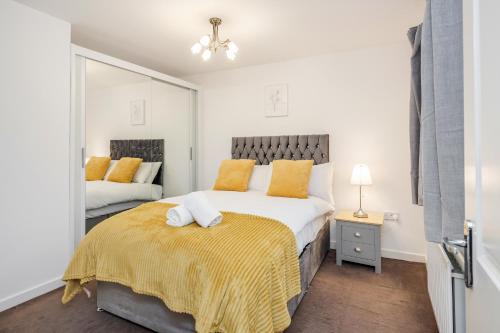a bedroom with a large bed with yellow pillows at Stunning 3BR house in Basildon in Basildon