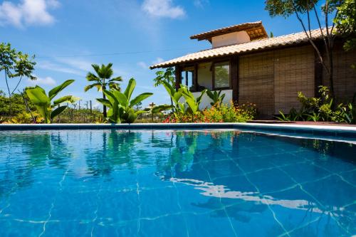 a swimming pool in front of a villa at Flow Beach House - Taipu de Fora - Península de Maraú in Barra Grande