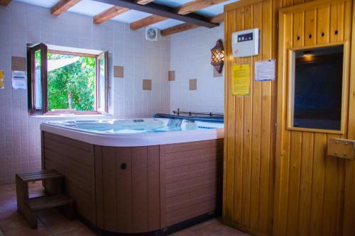 a bathroom with a tub and a window in it at La Erilla in Braojos de la Sierra