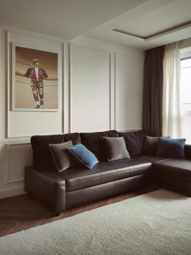 a living room with a leather couch and a picture at Modern Classic 2 bedroom apartment near Most City in Dnipro