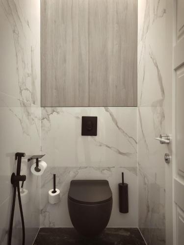 a bathroom with a black toilet and marble walls at Modern Classic 2 bedroom apartment near Most City in Dnipro