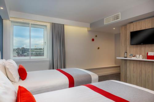 a hotel room with two beds and a television at Holiday Inn Express Dublin City Centre by IHG in Dublin