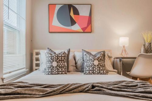 a bedroom with a bed with pillows and a painting at 3Bedroom 2Bathroom close to historic downtown fast wifi in McKinney