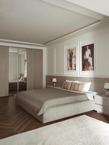 a bedroom with a large bed with two pictures on the wall at Modern Classic 2 bedroom apartment near Most City in Dnipro