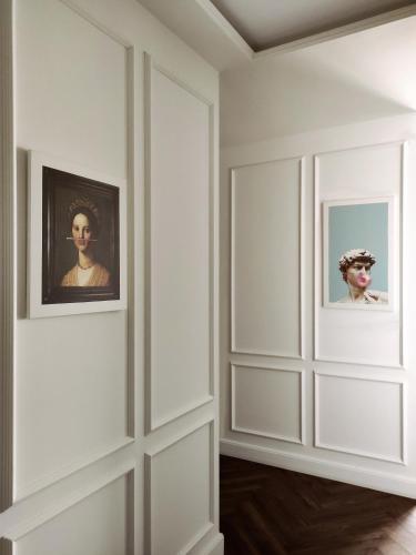 a room with white walls and two framed portraits at Modern Classic 2 bedroom apartment near Most City in Dnipro