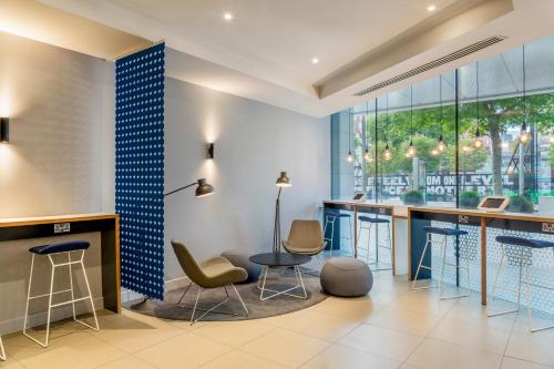 a lobby with a bar with chairs and tables at Holiday Inn Express Dublin City Centre by IHG in Dublin