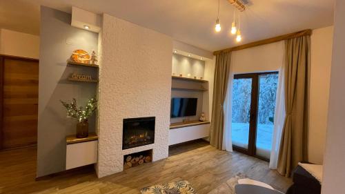 ein Wohnzimmer mit einem Kamin und einem TV in der Unterkunft Apartman Pinewood Divcibare in Divčibare