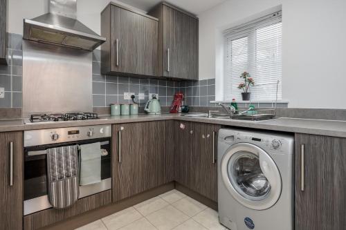 a kitchen with a washer and a washing machine at Stunning 3BR house in Basildon in Basildon