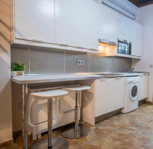 una cucina con bancone, lavatrice e asciugatrice di Apartamento céntrico a 10 minutos de la Alhambra a Granada