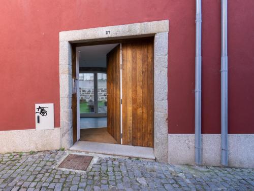 a door to a building with a red wall at Habitatio - Foz by LuxiStay in Porto