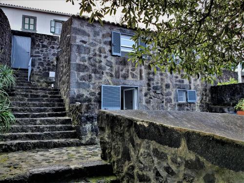 a stone house with stairs in front of it at Casa São Miguel in São Roque do Pico