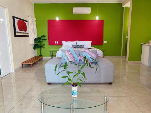 a living room with a couch and a red wall at Casa Mia in Puerto Escondido