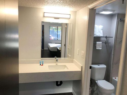 a bathroom with a sink and a toilet and a mirror at Studio 6 Sacramento, CA Natomas in Sacramento