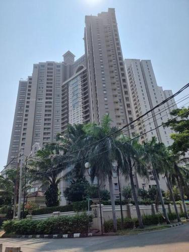 a group of tall buildings with palm trees in front at Hunian dekat T I Ancol, pintu Toll, Itc Mangga dua in Jakarta