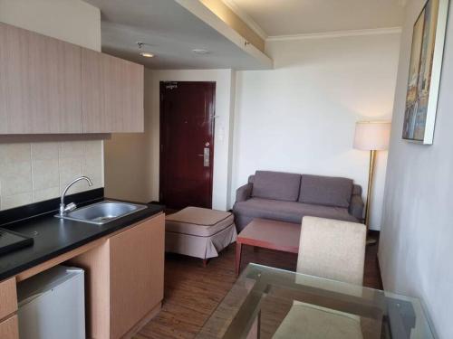 a kitchen with a sink and a couch in a room at Hunian dekat T I Ancol, pintu Toll, Itc Mangga dua in Jakarta