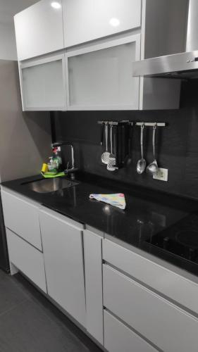 a kitchen with white cabinets and a black counter top at Luxury Arinaga in Arinaga