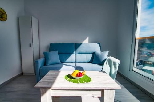 salon ze stołem i niebieską kanapą w obiekcie Neues Apartment am Strand w mieście Arguineguín