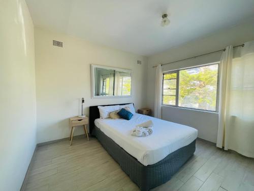 Un dormitorio con una cama grande y una ventana en Lotus Stay Manly - Apartment 29A, en Sídney