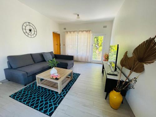 a living room with a blue couch and a table at Lotus Stay Manly - Apartment 29A in Sydney
