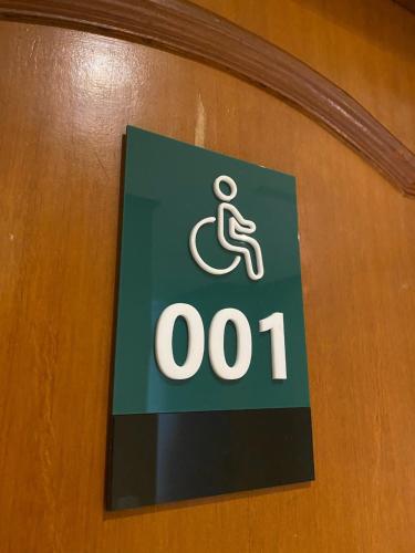 a sign on a door with a person in a wheelchair at Hotel Capital Das Pedras in Teófilo Otoni