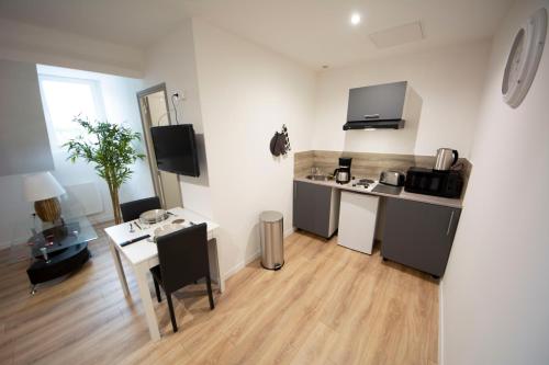 Il comprend un salon avec une cuisine et une table avec un bureau. dans l'établissement MALËiKA !!! Superbe T2 HOME STAGING avec parking gratuit !!!, à Saint-Quentin