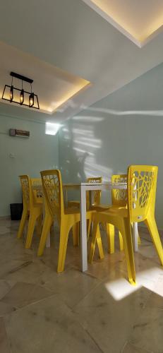 a yellow table and chairs in a room at BayView Villas Condo - Premium Unit in Port Dickson