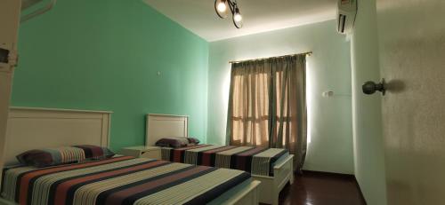 two beds in a room with blue walls at BayView Villas Condo - Premium Unit in Port Dickson