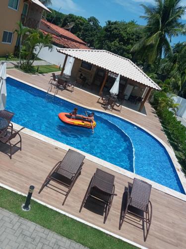een afbeelding van een zwembad met een boot erin bij Guarajuba! Excelente localização, Lindo, confortável e decorado! in Guarajuba