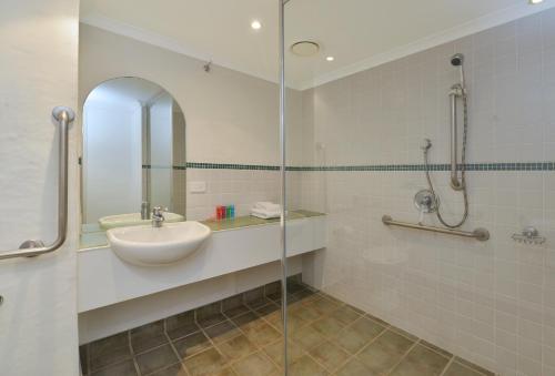 een badkamer met een wastafel en een glazen douche bij Reef Club Resort in Port Douglas