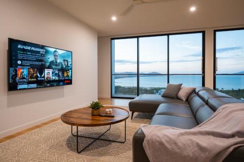 a living room with a couch and a table at Incredible Views, Open Spaces, Luxury Escapes Townsville Villa in Belgian Gardens