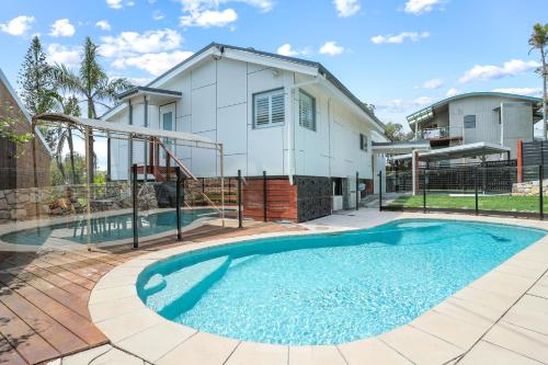 a house with a swimming pool in front of a house at Luxe Coastal Abode, Marcus Beach in Marcus Beach