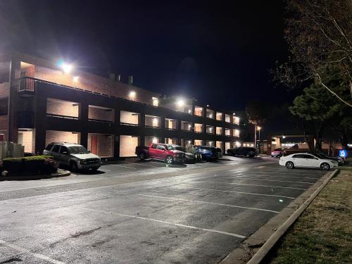 a parking lot with cars parked in front of a building at Motel 6 Oklahoma City OK Fairgrounds West in Oklahoma City