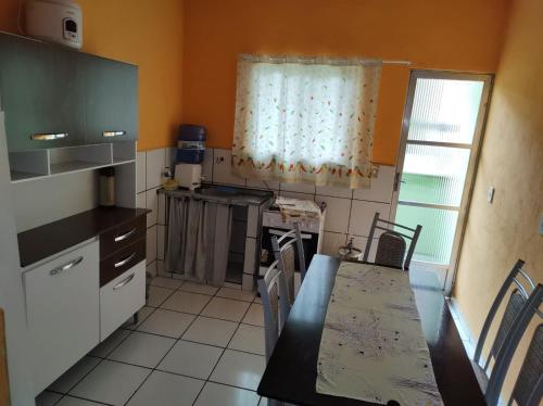 a kitchen with a table and a counter top at Apartamento Dulplex Diária/Temporada in Angra dos Reis