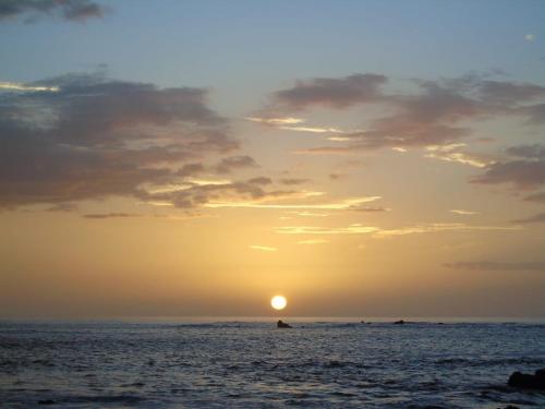 a sunset over the ocean with the sun in the sky at Chalet San Juanillo in San Juanillo