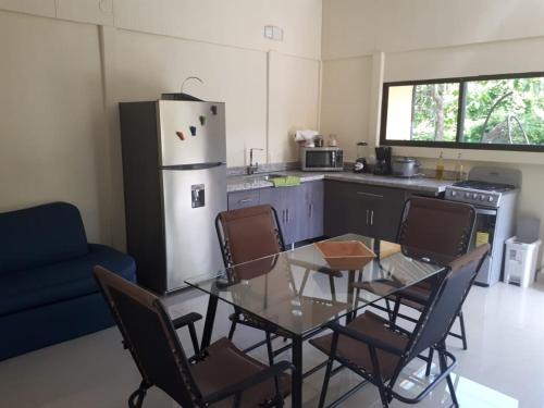 a kitchen with a table and chairs and a refrigerator at Chalet San Juanillo in San Juanillo