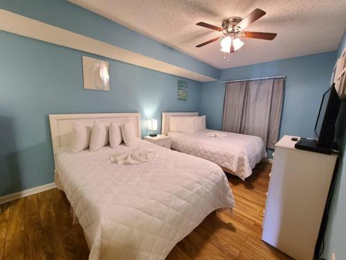 Atlantica Resort III في ميرتل بيتش: غرفة نوم بسريرين ومروحة سقف