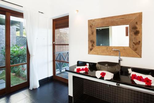 bagno con lavandino e specchio di Villas de Jardin self-catering a Port Glaud