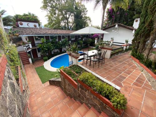 Cette maison dispose d'une terrasse avec une table et un parasol. dans l'établissement Casa Dalinda, à Valle de Bravo