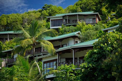 a building on the side of a hill with trees at Villas de Jardin self-catering in Port Glaud