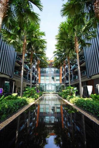 空望的住宿－@T精品酒店，一座棕榈树环绕的大建筑