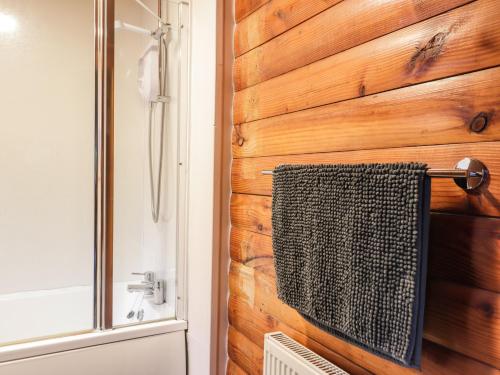 a bathroom with a towel hanging on a wooden wall at Spruce Lodge in Strathpeffer