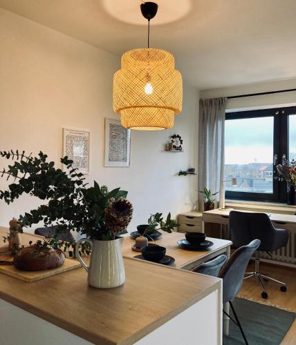 a kitchen with a table with a vase with a plant at Schickes, Stilvolles und Helles Apartment in Münster in Münster